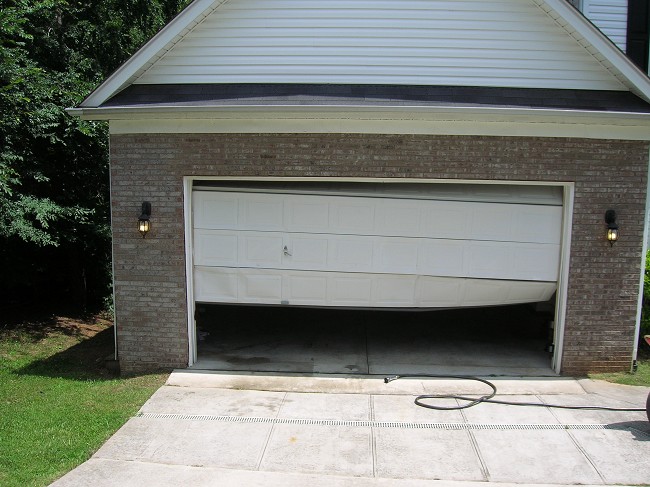Garage door that has been hit by a vehicle. Academy Door can replace